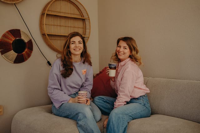 Daniëlle en Stephanie samen op de bank met koffie